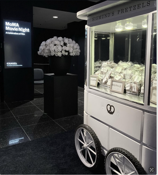 Sigmund's Pretzel Cart  Catering 2025 : 1 cart, 1 server, 2-4 hours of service, 300 individually wrapped assorted bite size pretzels, served room temperature  Flavor options: original (100), truffle cheddar (100), everything (100), churro (100)